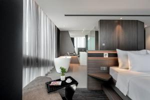 Un pat sau paturi într-o cameră la Draco Hotel & Suites