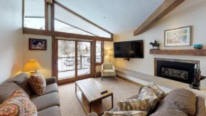a living room with a couch and a fireplace at Slopeside 3 Bedroom Gold-rated Residence At Golden Peak Steps To Vail Village in Vail