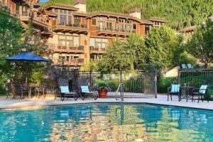 a hotel with a swimming pool in front of a building at Slopeside 3 Bedroom Gold-rated Residence At Golden Peak Steps To Vail Village in Vail