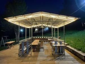 un tavolo da picnic sotto un padiglione di notte di GLAMPING WOLF MOUNt a Margahovit