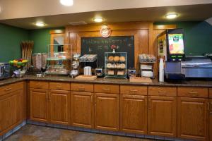 a kitchen with wooden cabinets and a counter with a refrigerator at AmericInn by Wyndham Thief River Falls in Thief River Falls