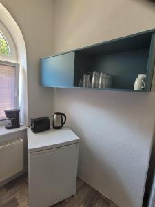 cocina con encimera blanca y armario azul en Waldemar-Appartement, en Rostock