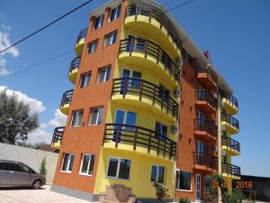 a yellow and orange apartment building with balconies at Casa Marea Neagra in Costinesti