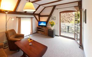un soggiorno con divano, tavolo e TV di Pension zur Scheune a Plau am See