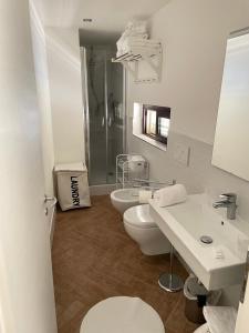 a bathroom with two sinks and a toilet and a shower at Lamezia Park Apartments in Lamezia Terme