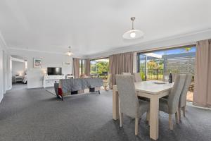 a dining room and living room with a table and chairs at Ruakaka River Retreat - Ruakaka Holiday Home in Ruakaka