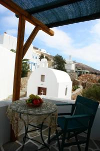 a table and chairs on a balcony with a white building at Irene Rooms in Chora Folegandros