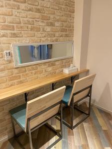 a desk with two chairs and a mirror on a brick wall at Small Resort Shima - Vacation STAY 96429v in Shima