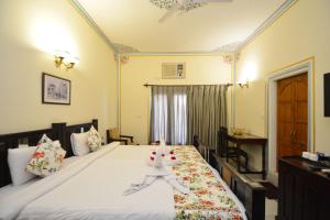 ein Schlafzimmer mit einem großen Bett mit weißer Bettwäsche in der Unterkunft Mahal Khandela-A Heritage Hotel In Jaipur City Center in Jaipur + 40 Fotos