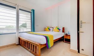 a bedroom with a large bed and a window at Itsy Hotels Vijaya Comforts, Coorg in Madikeri