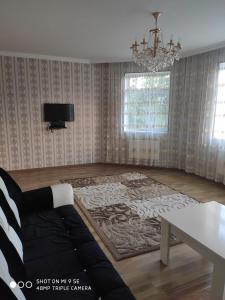 ein Wohnzimmer mit einem Sofa und einem TV an der Wand in der Unterkunft Villa in Qabala in Qəbələ