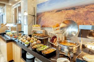 Ramon Suites by Smart Hotels في متسبيه رامون: طابور بوفيه مع انواع كثيره من الطعام