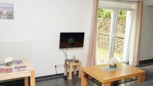 uma sala de estar com um sofá e uma televisão na parede em Blumenberg Ferienwohnung em Hamburgo