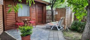 a patio with a table and chairs in front of a cabin at Szőlősi Diófa Vendégház in Balatonszőlős
