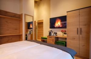1 dormitorio con 1 cama y TV en la pared en Hotel Tannenhof, en Zermatt