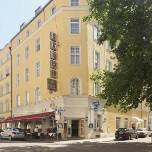 a large yellow building with a sign on it at Carlton Astoria in Munich
