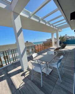a patio with a table and chairs on a deck at MAR60 Apartments in Caorle