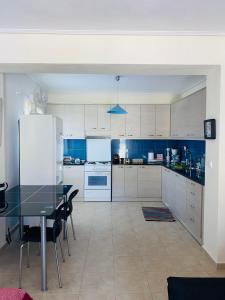 a large kitchen with a table and a refrigerator at Mikro Amoni Beach Villa in Pefkali