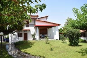 une maison blanche avec une cour devant elle dans l'établissement Villa Kontos, à Kamena Vourla