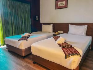 Postel nebo postele na pokoji v ubytování Neo Hatyai Hotel