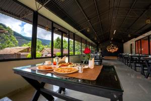 Vattavada的住宿－Stephen's Legacy，用餐室配有餐桌和食物