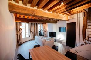 a living room with a table and a couch at Duplex colombage centre historique d'Orléans in Orléans