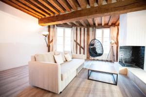 a living room with a white couch and a fireplace at Duplex colombage centre historique d'Orléans in Orléans +4 photos