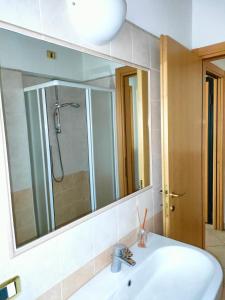 uma casa de banho com um lavatório e um espelho grande em Da Cate - Appartamento al mare em Grottammare