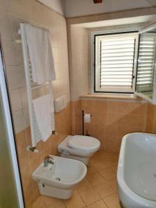 uma casa de banho com um WC branco e um lavatório. em Da Cate - Appartamento al mare em Grottammare