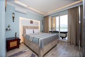 a bedroom with a bed and a large window at Aquamarine House in Tivat
