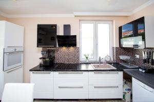 a kitchen with white cabinets and black counter tops at Aquamarine House in Tivat
