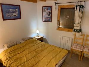 1 dormitorio con 1 cama, 1 silla y 1 ventana en Chalet proche Morzine et lac Léman WIFI offert, en Le Biot