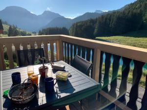 una mesa de picnic en un balcón con vistas a las montañas en Chalet proche Morzine et lac Léman WIFI offert, en Le Biot