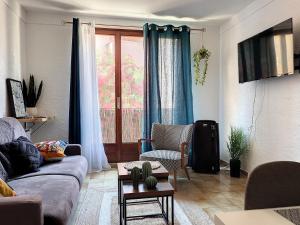 a living room with a couch and a window at APP' ART CENTRE PLAGE + PARKING GRATUIT in Collioure