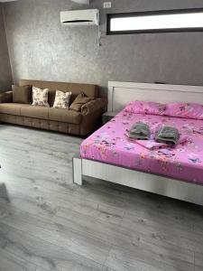 a bedroom with a pink bed and a couch at Casa Florenta in Venus