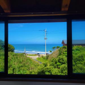 a view of the ocean from a window at koco in Nishinoomote