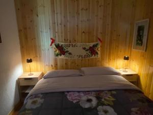 a bedroom with a bed with two nightstands and two lamps at Parco gran paradiso in Rhemes-Saint-Georges