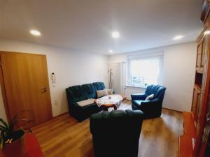 uma sala de estar com duas cadeiras e uma mesa em Unsere Ferienwohnung in Lengenfeld. em Lengenfeld