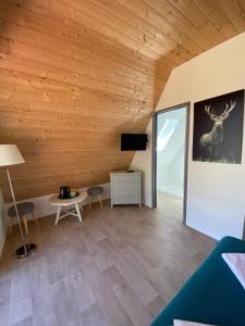 a living room with wooden walls and a large window at Hotel Le Chalet in Sainte-Marie-de-Campan