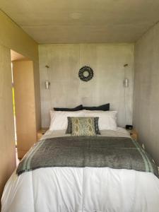 a bedroom with a large bed with a white bedspread at Unique luxurious cabin on sea view working croft in Garrabost