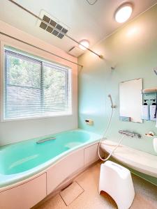 een badkamer met een bad en een raam bij びわ湖ハイドアウト in Takashima