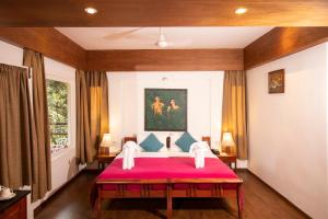a bedroom with a bed with a red blanket at Blackberry Hills Munnar- Nature Resort & Spa in Munnar