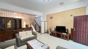 - un salon avec un canapé et une télévision dans l'établissement Song Yuan Ju Homestay, à Hualien