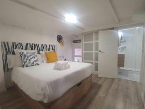 a bedroom with a large white bed and a walk in shower at Indulge in Seville Feria 106 in Seville