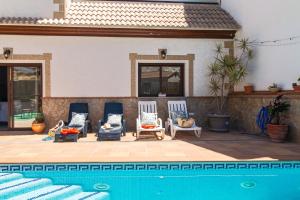 un grupo de sillas sentadas junto a una piscina en Casa La Loma de Arenas, en Arenas