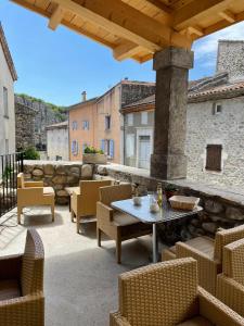 un patio con tavolo e sedie su un edificio di La Secrète a Vogüé