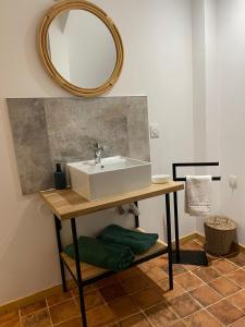 baño con lavabo y espejo en la pared en La Secrète, en Vogüé