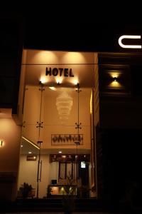 a hotel sign on the side of a building at night at Hotel Centauri in Thiruvalla