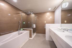 a bathroom with a shower, sink, and tub at Namba Oriental Hotel in Osaka