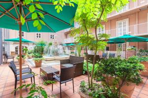 un patio al aire libre con mesas, sillas y sombrillas en Namba Oriental Hotel, en Osaka